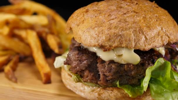 Grande hambúrguer de carne especial com batatas fritas close-up — Vídeo de Stock