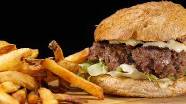 Close up de um hambúrguer grelhado com cebola e batatas fritas — Vídeo de Stock