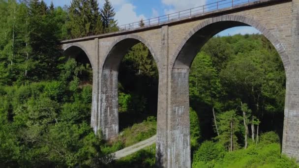 Puente ferroviario en las colinas del bosque - vista aérea sobre un viejo viaducto — Vídeos de Stock