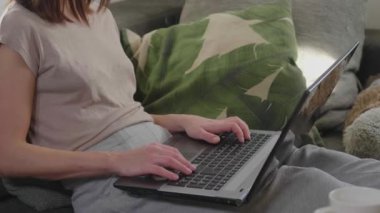 Genç kadın kanepede oturur ve onu laptop İnşaat