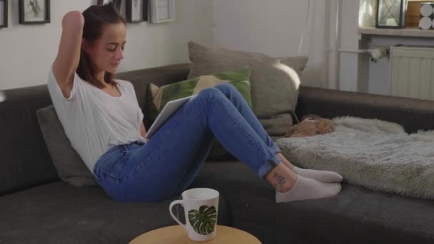 Νεαρή Γυναίκα Που Κάθεται Στον Καναπέ Τον Υπολογιστή Tablet — Αρχείο Βίντεο