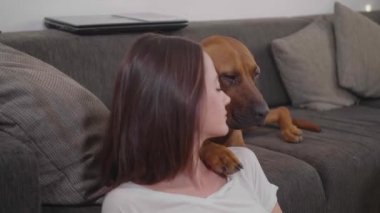 Güzel kız evde köpeğiyle oynuyor