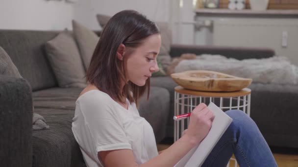 Young Woman Sits Floor Writes Some Notes Her College Block — Stock Video