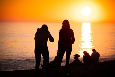 Silhouetts fotoğraf çekmek ve günbatımında eğleniyor insan 