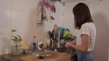 Genç kadın tatlı su tencereye doldurur.