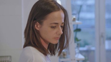 İç çamaşırlı yorgun kız mutfakta kahvaltı çayı içiyor.