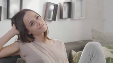 Genç bayan kanepede dinleniyor.