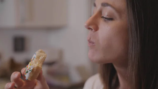 Молодая женщина ест сладкие пончики с сахаром — стоковое фото