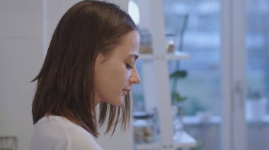 Yorgun bir kız iç çamaşırı mutfakta sıcak çay içmek kadeh yukarıya kapatmak