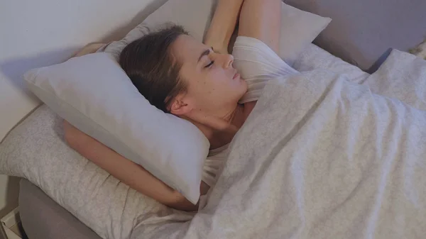 Спящая девушка в своей спальне просыпается утром — стоковое фото