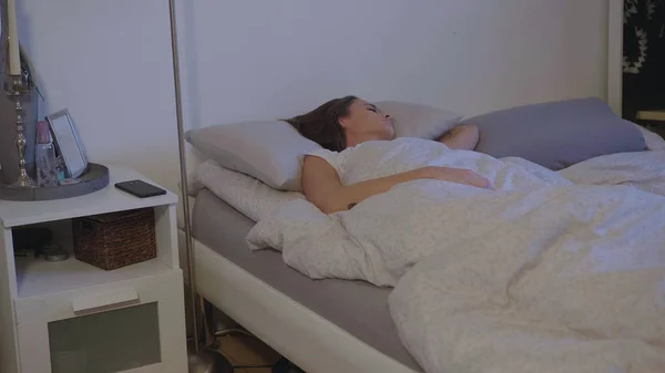 Young woman in her bed wakes up in the early morning — Stock Photo, Image