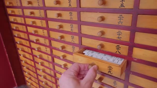 Omikuji - papeles de fortuna al azar en un templo budista o santuario sintoísta - TOKYO, JAPÓN - 12 DE JUNIO DE 2018 — Vídeo de stock