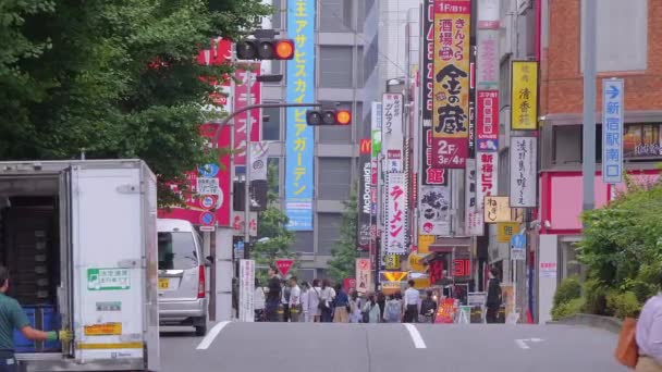 Walking through the city of Shinjuku - a busy district in Tokyo - TOKYO, JAPAN - JUNE 17, 2018 — Stock Video