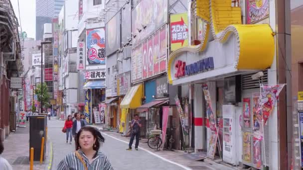 Walking through the city of Shinjuku - a busy district in Tokyo - TOKYO, JAPAN - JUNE 17, 2018 — Stok Video