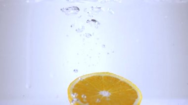 Ağır çekimde su içine portakal dilimleri düşmek