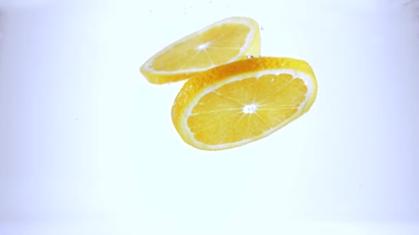 Färska skivor citroner falla i vatten — Stockvideo