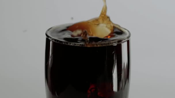 Un soupçon de glace froide Cola - glaçons tombent dans un verre de soude — Video