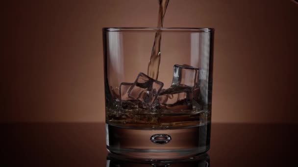 Наливание виски в стакан со льдом - красивая замедленная съемка — стоковое видео