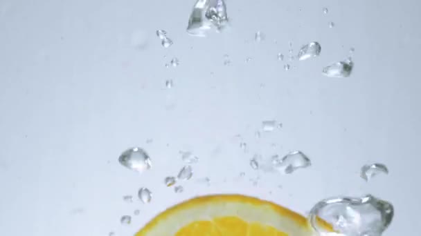 Свежие ломтики лимона в воде - замедленная съемка — стоковое видео