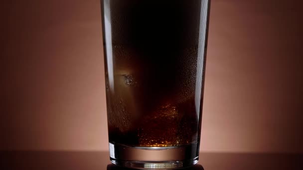 Cola in ein Glas mit Eiswürfeln gießen - erfrischendes Soda — Stockvideo