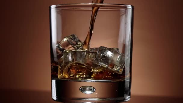 Gieten Whiskey in een glas met ijs - prachtige slow-motion shot — Stockvideo