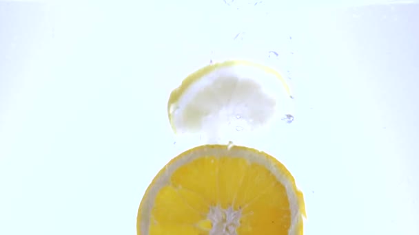 Свежие ломтики лимона в воде - замедленная съемка — стоковое видео
