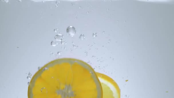 Frische Zitronenscheiben im Wasser - Zeitlupenaufnahme — Stockvideo