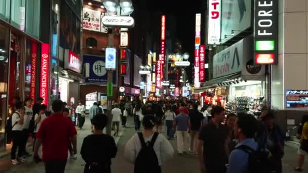 Shibuya 的霓虹灯广告和城市灯光--夜间拥挤的地区----日本东京----2018年6月12日 — 图库视频影像