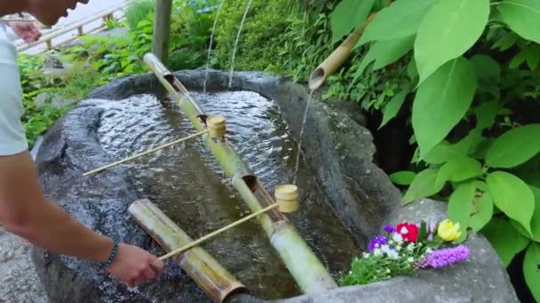 Фонтан ритуальной очистки в японском храме - ТОКИО, Япония - 12 июня 2018 г. — стоковое видео