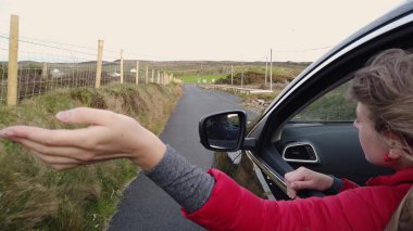 Genç bir kadın güneşli bir günde araba sürmekten hoşlanır - Malin, İrlanda - 11 Mayıs 2019