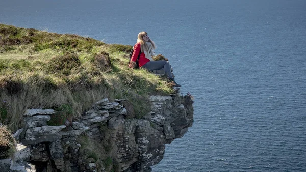 Młoda Kobieta Siedzi Skraju Urwiska Irlandzkim Zachodnim Wybrzeżu Fotografia Podróży — Zdjęcie stockowe