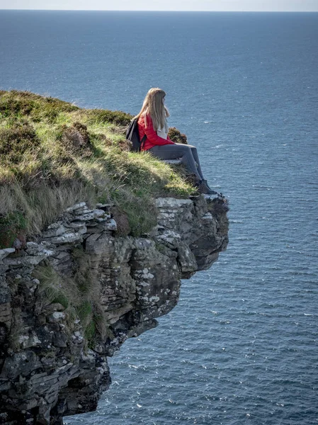Młoda Kobieta Siedzi Skraju Urwiska Irlandzkim Zachodnim Wybrzeżu Fotografia Podróży — Zdjęcie stockowe