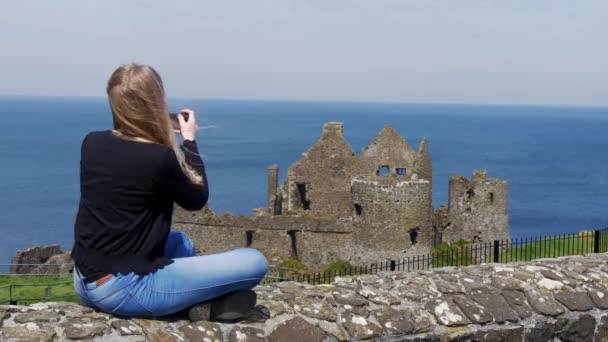 Genç Kadın Kuzey Rlanda Dunluce Kalesi Fotoğraflarını Çeker — Stok video