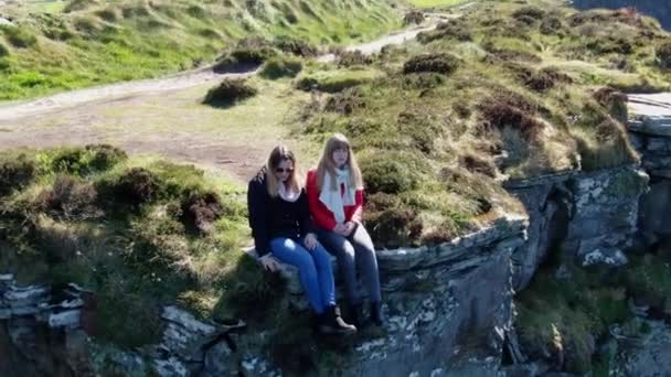 Dos Chicas Sientan Borde Los Famosos Acantilados Moher Irlanda — Vídeo de stock