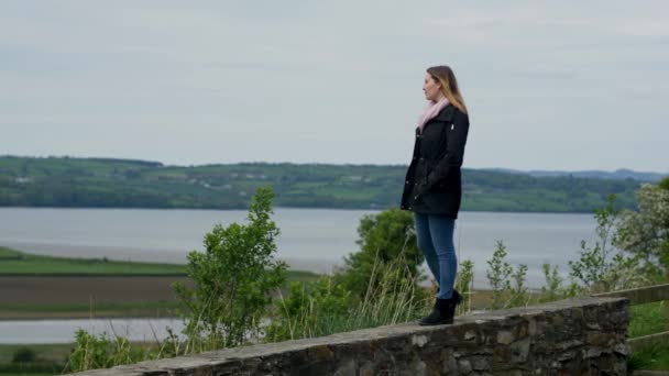 Junge Frau entspannt sich in der wunderschönen grünen Natur Irlands — Stockvideo