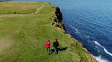 İki kız Moher ünlü Cliffs kenarında yürümek 