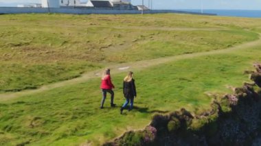 İki kız Moher ünlü Cliffs kenarında yürümek 