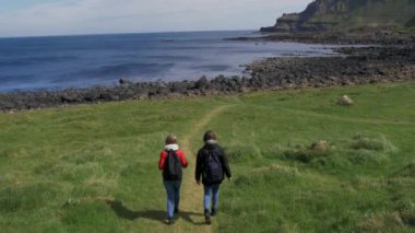 İki kız Moher ünlü Cliffs kenarında yürümek 