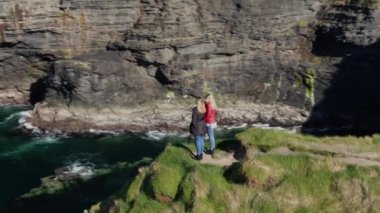 İki kız Moher ünlü Cliffs kenarında yürümek 