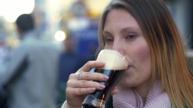Genç kadın Galway kentinde İrlandalı bir bira içiyor - seyahat fotoğrafçılığı