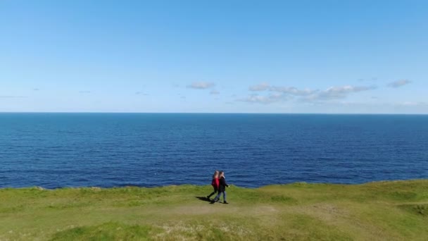 二人の女の子がモハーの有名な崖の端に沿って歩く — ストック動画
