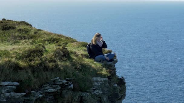 Молодая Женщина Сидящая Краю Утёса Западном Побережье Ирландии Фотографии Путешествий — стоковое видео