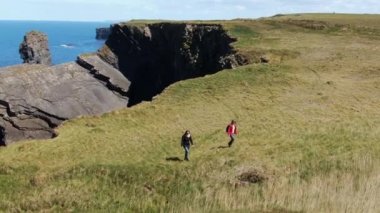 İki kız Moher ünlü Cliffs kenarında yürümek 