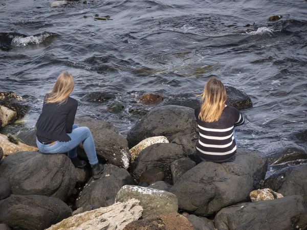 Due Ragazze Siedono Sugli Scogli Della Causeway Coast Irlanda Del — Foto Stock