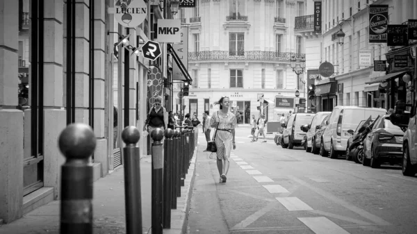 French woman walks through the streets of Paris - CITY OF PARIS, FRANCE - JULY 29, 2019