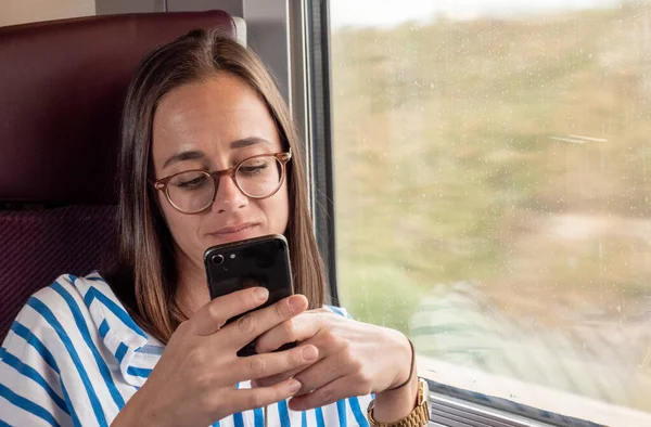 Young Woman Sits Train Reads Text Messages Cell Phone Travel — Stock Photo, Image
