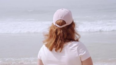 Güzel kız okyanus kıyısındaki sahilde eğleniyor. Yaz tatili.