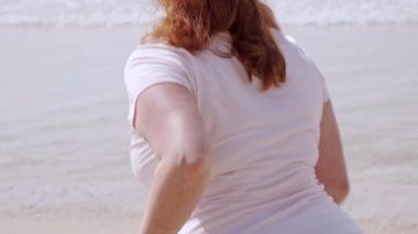 Güzel kız okyanus kıyısındaki sahilde eğleniyor. Yaz tatili.