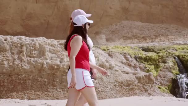 Hermosa chica camina en una playa de arena en el frente del mar — Vídeo de stock
