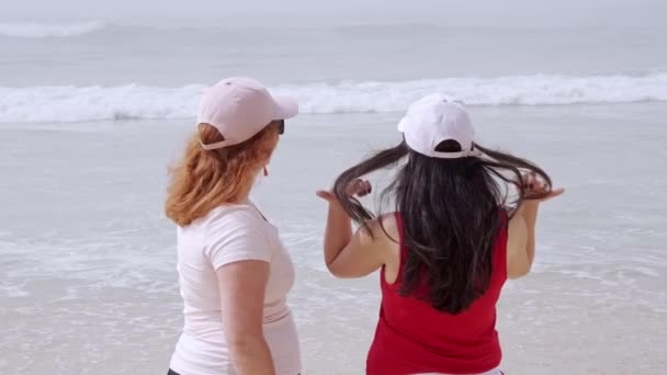 Ідеальний день на пляжі - молоді жінки насолоджуються відпочинком в океані — стокове відео
